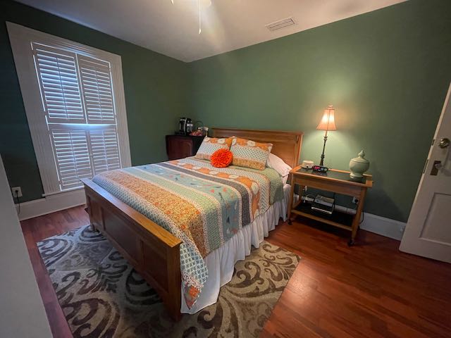 Room view from entrance of double bed, dresser, desk and chair